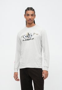 T-shirt a maniche lunghe di un grigio chiaro con una stampa grafica che presenta occhi cartoon e una forma triangolare; design in cotone morbido, colletto a giro. 