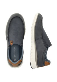 Slip-on-skor i mörkgrått och marinblått material; texturerad ovandel med en kontrasterande brun detalj; lätt vit sula med mönster för grepp.