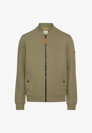 Zielona oliwkowa kurtka o fasonie bombowca, z zamkiem błyskawicznym z przodu, kontrastową pikowaną fakturą oraz dwiema przednimi kieszeniami z czarnymi guzikami.