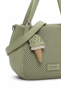 Sac à main en cuir perforé vert clair avec doubles poignées, un charm en forme de cornet de glace et une petite étiquette de marque en métal "SURI FREY."
