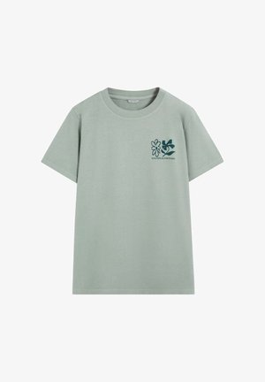 Miętowozielona bawełniana koszulka z krótkimi rękawami, okrągłym dekoltem i nadrukiem z przodu przedstawiającym dwa kwiatowe wzory w ciemnozielonym kolorze.