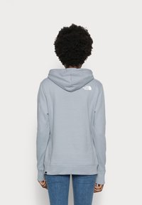 Felpa grigia chiaro realizzata in un mix di cotone e poliester. Presenta un cappuccio con coulisse e un piccolo logo bianco sul retro. Vestibilità comoda e polsini a costine.
