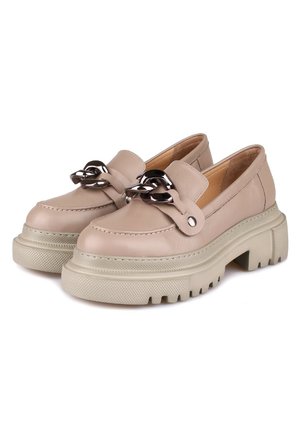 Beige leren instappers met een dikke crèmekleurige zool, voorzien van een zilverkleurige kettingaccent op de voorzijde en textuurdetails op de zool.