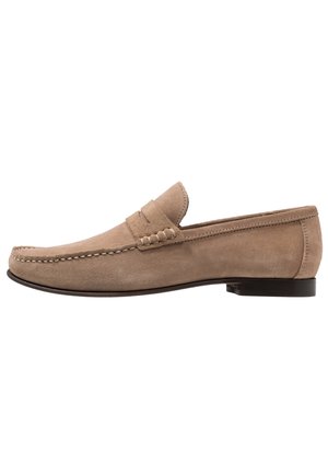 Beigenvärinen mokkanahkainen miesten loafers-kengät, joissa ommeltu mokantyyppinen kärki, matala korko ja pennynauhainen yksityiskohta, esitetty sivulta valkoisella taustalla.