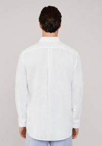 Weißes Langarmhemd aus Leinen. Mit einem Button-Down-Kragen und einer Rückenfalte, abgerundhem Saum und geknöpften Manschetten.