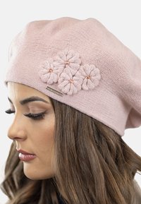 Beret tricotat roz, dotat cu trei aplicații florale texturate și un mic accent metalic. Material moale, ușor, cu un design lejer.