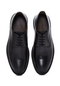 Zwarte leren veterschoenen met een gladde afwerking, ronde neus en minimale details. Bevat een subtiele textuur en rubberen zool.