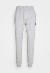 Graue Sweatpants aus weichem Material, mit einem elastischen Bund und Kordelzügen sowie gerippten Bündchen. Kleines Logodetail in der Nähe der Tasche.