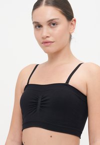 Fekete rövidített camisole, vékony állítható pántokkal, középen ráncolt részletezéssel és sima, rugalmas anyagból készült kivitelben.