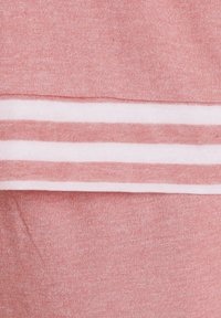 Hellrosa Baumwollstoff mit einer weichen Textur, der entlang der unteren Kante weiße Streifen aufweist. Das Design zeichnet sich durch ein sauberes, einfaches Muster aus.