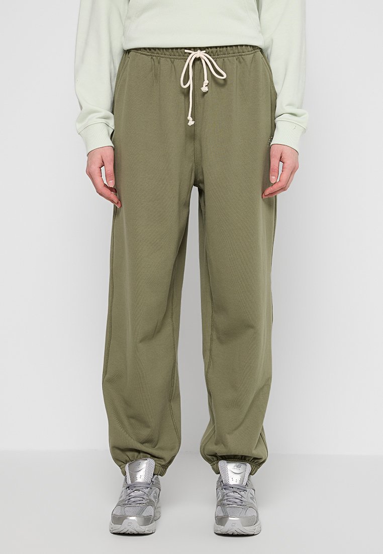 Joggers vert olive avec une taille élastique et un cordon de serrage. Fabriqués en tissu doux, ils présentent une coupe décontractée et des poignets fuselés.