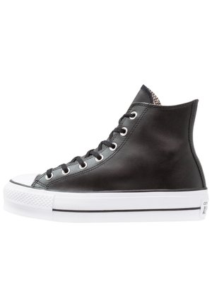 Sneaker alta nera in pelle con suola in gomma bianca, punta rotonda, lacci piatti e occhielli metallici. Presenta dettagli testurizzati all'interno.