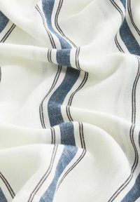 Tejido de algodón con base blanca, con franjas azules y marrones. Texturizado, con un suave caído y un patrón de diseños de franjas alternantes.