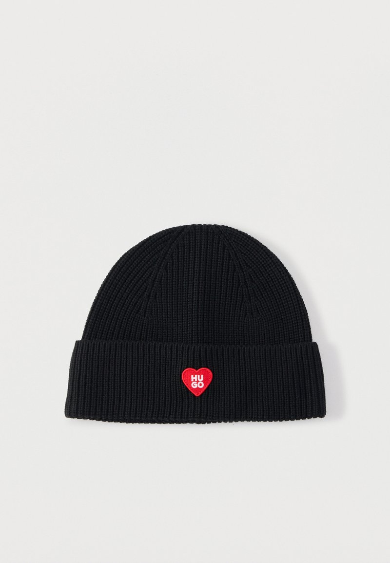 Gorro de punto negro con textura acanalada, con puño doblado y parche rojo en forma de corazón con el texto "HUGO".
