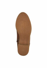 Chaussure en cuir marron avec une semelle en caoutchouc texturé, dotée d'un léger talon et de coutures près de la tige pour plus de détail.