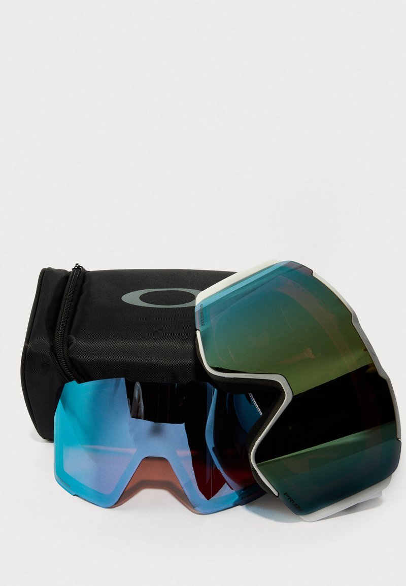 Zonnebrillen met een zwarte case, met twee paar; een met blauwe en rode lenzen, de andere met groene en zwarte lenzen, slank ontwerp.