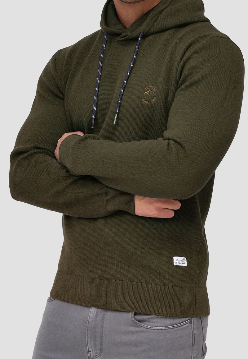 Olivgrüner Hoodie mit strukturierter Oberfläche, navyfarbene Kordeln, vordere Logodetails sowie gerippte Bündchen und Saum. Baumwoll-Mischgewebe.