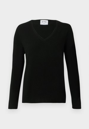 Suéter negro de manga larga y cuello en V, fabricado en material suave, con una textura sutil y un diseño minimalista. Etiqueta visible en el escote.