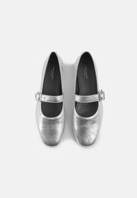 Scarpe Mary Jane metalliche argento con punta rotonda, cinturino regolabile con fibbia e una texture liscia. Soletti neri visibili all'interno.