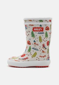 Gummistøvle med hvid bund, farverige vintertematiske mønstre og rødt logo. Har hvidt øvre kant og tekstureret rød ydersål.