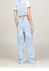 Ljusblå vida jeans i denim med två bakfickor och en liten logopatch. Ytan verkar mjuk och något urtvättad.