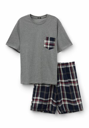 Ensemble de pyjama composé d'un t-shirt gris à manches courtes avec une poche poitrine à carreaux, associé à un short à carreaux bleu marine, rouge et blanc, sur fond blanc.