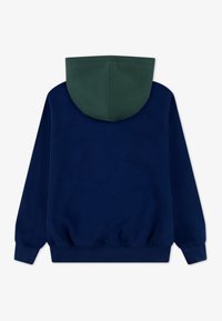 Námornícko modrá mikina s zelenou vnútornou kapucňou. Vyrobená z mäkkého materiálu, má dlhé rukávy, klokanie vrecko a voľný strih.