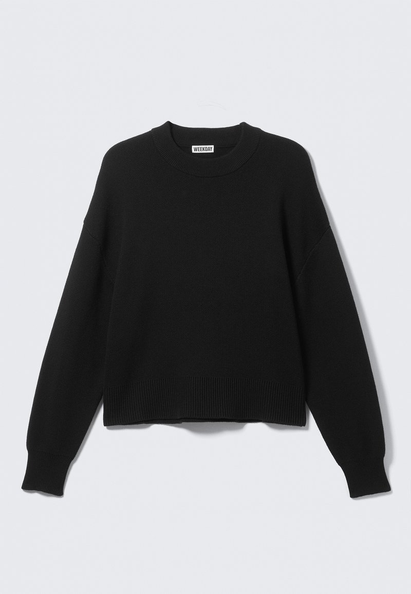 Pull noir tricoté avec un col rond, des coutures tombantes aux épaules, et des poignets et ourlet côtelés. Design simple et uni, sans motifs.