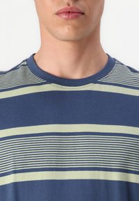 Puuvillane T-särk horisontaalsete triipudega tumesinises ja helesinises. Klassikaline ümmargune kaelus, pehme tekstuur ja lühikesed varrukad.