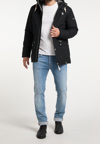 Veste isolante noire avec capuche, doublure grise et cordons blancs. Elle présente une fermeture éclair et à boutons-pression, de grandes poches avant, et un accent vert.