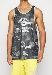 Black and gray mesh tank top featuring a mottled design. White text states "PROPERTY OF" and "LIKE STANDARD ISSUE." Sleeveless, rounded neckline.