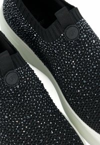Baskets noires à enfiler avec un dessus texturé orné de strass noirs brillants, un col en maille élastique et une semelle en caoutchouc blanche.