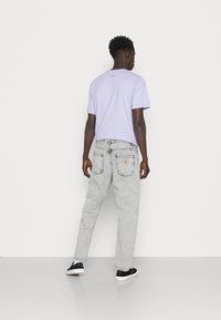 Carhartt WIP NEWEL PANT - Calças de ganga de corte afunilado - black sun washed