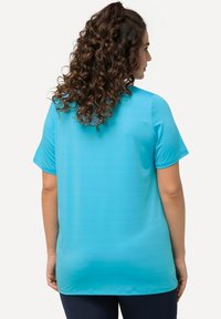 Türkisfarbiges Kurzarmshirt aus glattem Stoff. Lockere Passform mit rundem Ausschnitt und geradem Saum, mit feiner Textur.