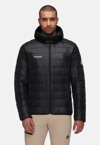 Zwarte pufferjack met een capuchon, voorzien van een doorgestikte design, een rits aan de voorkant en een logo op de borst. Materiaal lijkt glanzend en geïsoleerd.