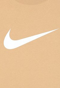 Beige sweatshirt med rund hals, prydd med en stor vit Nike swoosh-logotyp. Materialet verkar mjukt med en slät textur.
