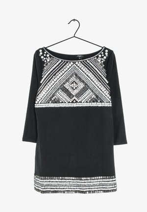 Top nero a maniche lunghe con una scollatura ampia. Presenta intricati motivi geometrici in paillettes bianche e argentate sul davanti e una texture liscia.