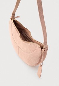 Ροζ σουέτ τσαντάκι χιαστί με καμπυλωτό σχέδιο, χρυσό φερμουάρ και ρυθμιζόμενο λουράκι. Διαθέτει ομαλή υφή και εσωτερική τσέπη.