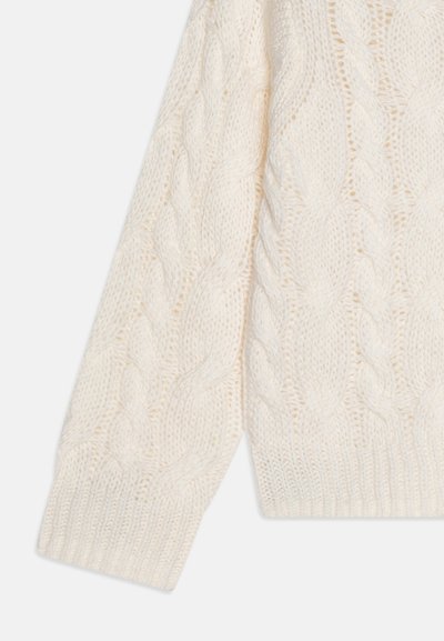 Kremfarget kabelstrikket genser med et teksturert mønster. Designet har tykke fletter og en ribbestrikket nederkant, som fremhever det strikkede stoffet.