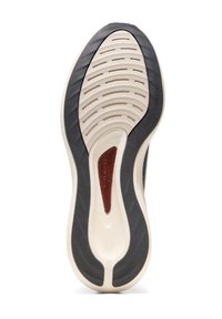 Schuhsohle mit einem wellenförmigen Profil. Farbkontrast mit einer cremefarbenen Gummibasis, strukturiertem schwarzen Rand und einem braunen Lederakzent.