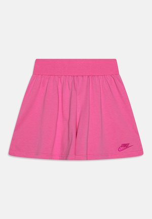 Różowa rozkloszowana spódnica z szerokim pasem i haftowanym logo Nike blisko brzegu na jednolitym jasnym tle.