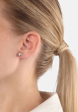 Pendientes de stud de metal en tono dorado con un cristal redondo y transparente en el centro; acabado suave y tamaño pequeño, adecuados para el uso diario.