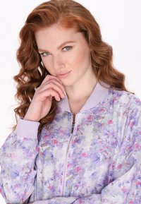 Paarse bloemen bomberjack van lichtgewicht, doorschijnende stof. Voorzien van een rits aan de voorkant en geribbelde manchetten, met een pastelpatroon.