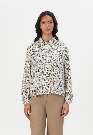 Lett, langermet bluse i beige med svart flekkmønster, knappestolpe foran og klassisk krage. Myk tekstur med avslappet passform.