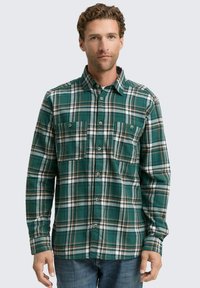 Groene geruite blouse van zachte stof, met twee borstzakken, een button-down kraag en contrasterende witte en bruine patronen.