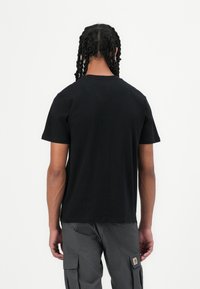 Black short-sleeve t-shirt with a round neck. Smooth texture, relaxed fit. Paired with gray cargo pants featuring side pockets.