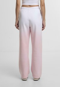 Pants made of soft fabric with an elastic waistband, featuring a gradient fade from white to light pink and wide-leg design.