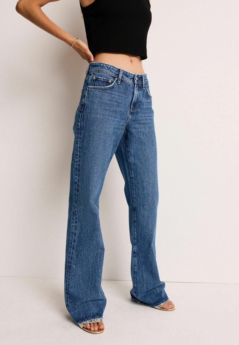 Ublegede blå jeans med høj talje og flagrende ben. Lavet af denim, med forlommer og kontraststikning.