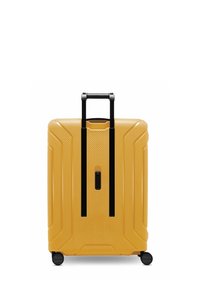 Valigia rigida di colore giallo brillante con finitura testurizzata, dotata di manico nero estraibile e quattro ruote nere per la mobilità.
