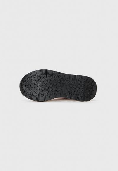 Semelle de chaussure en caoutchouc noir présentant un motif texturé avec des designs hexagonaux et linéaires pour une traction et une durabilité optimales.